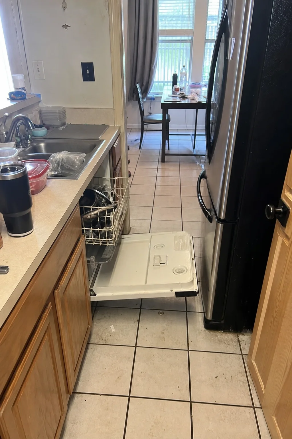Cramped Dallas kitchen with an open dishwasher blocking the main walkway