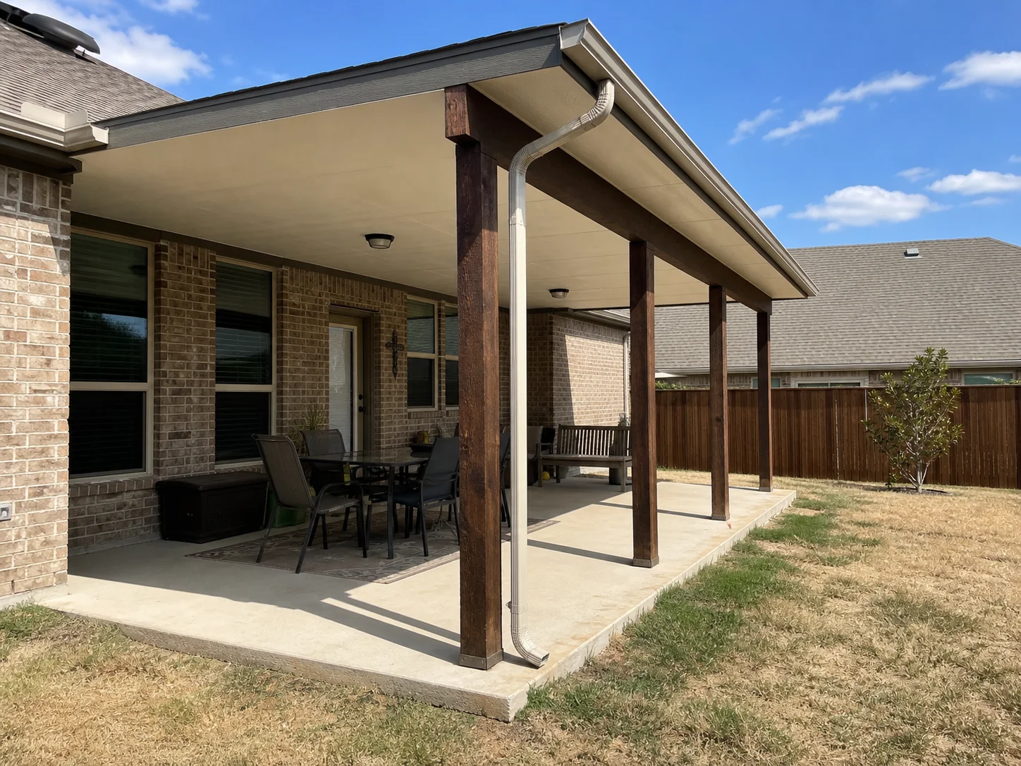 Solid patio cover with gutters attached to a Dallas brick home