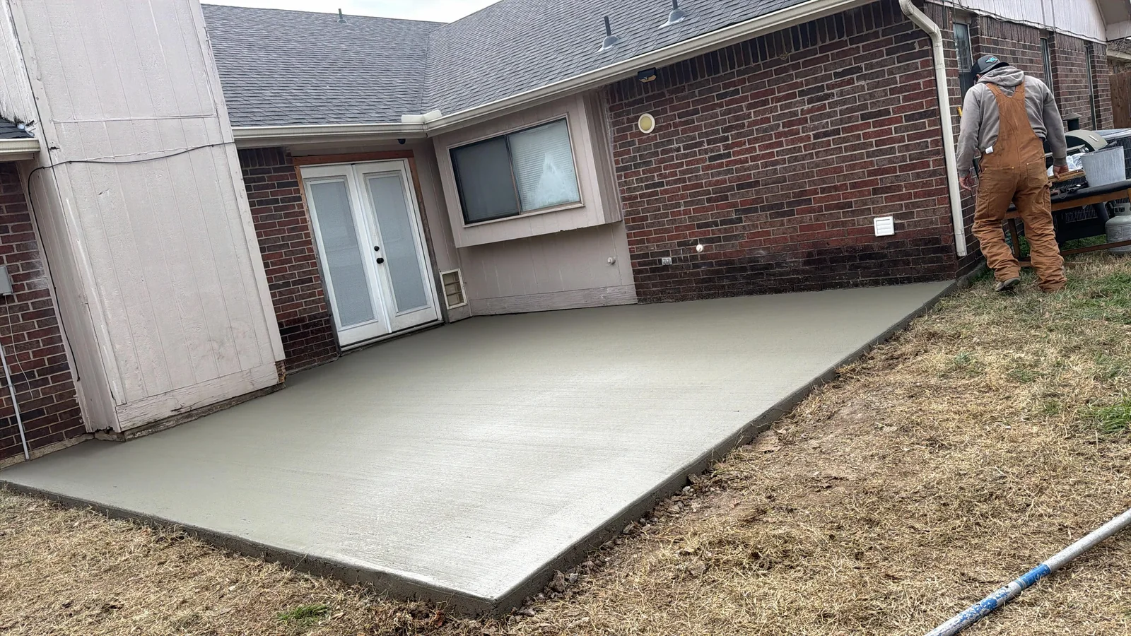 New concrete patio beside a brick home in the Dallas area