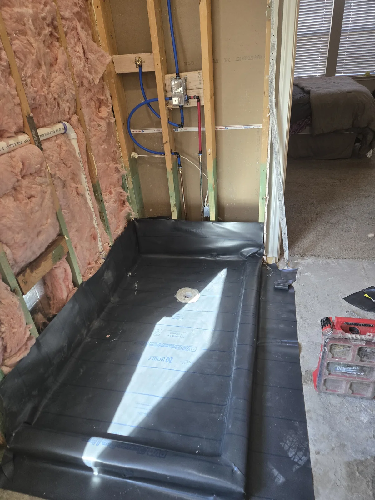Drainage channel installed beside a patio and brick exterior wall